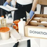 Close-up of donation box with various food items and supplies for community support.